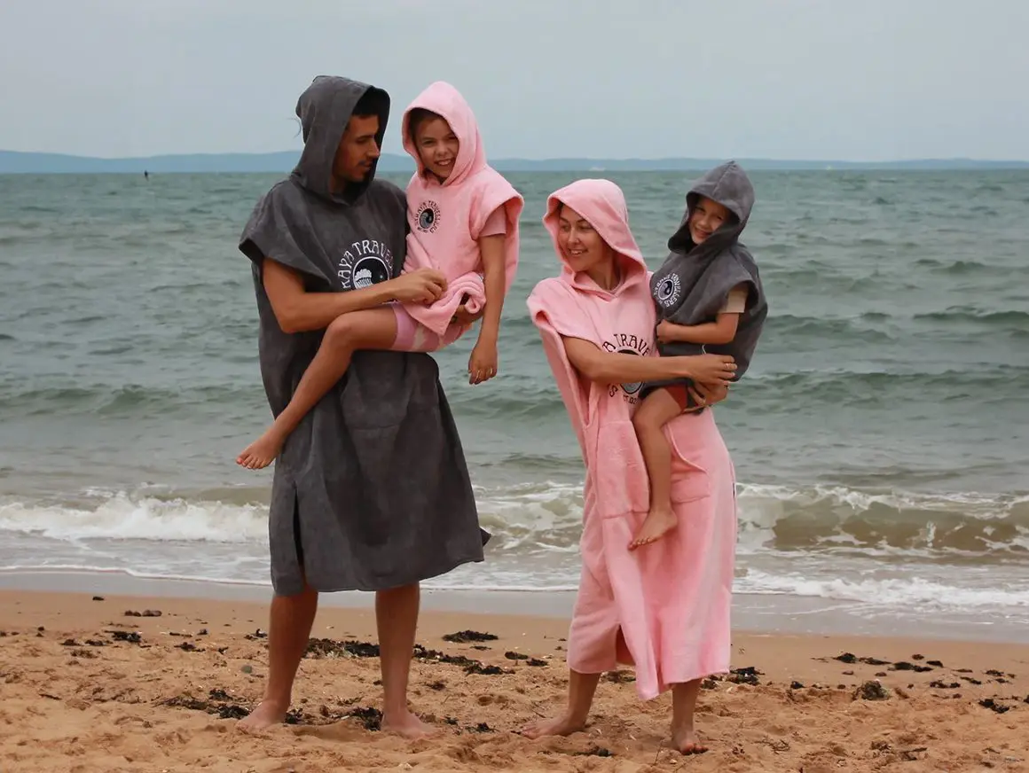 A family on the beach in their robes