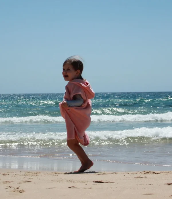 A little girl is running on the beach