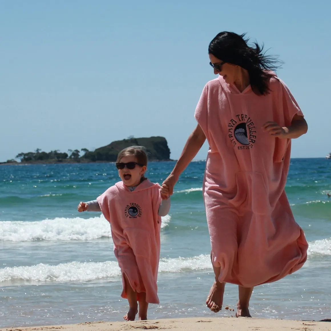 A woman and child walking on the beach