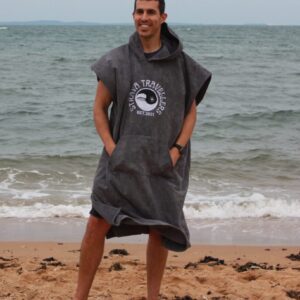 A man standing on the beach wearing a towel