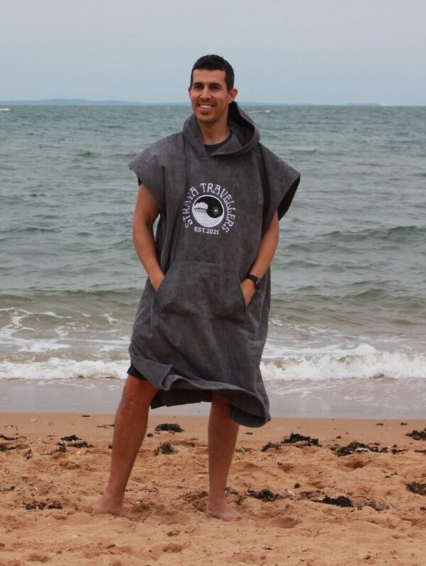 A man standing on the beach wearing a towel